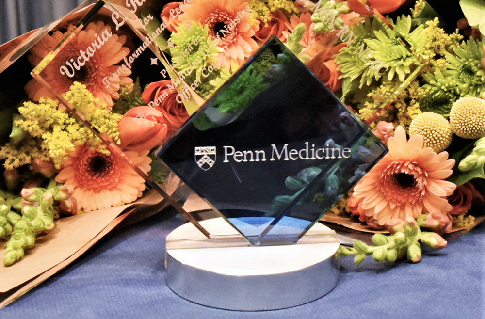 A 2021 Nursing Clinical Excellence Award sits among bouquets of flowers.